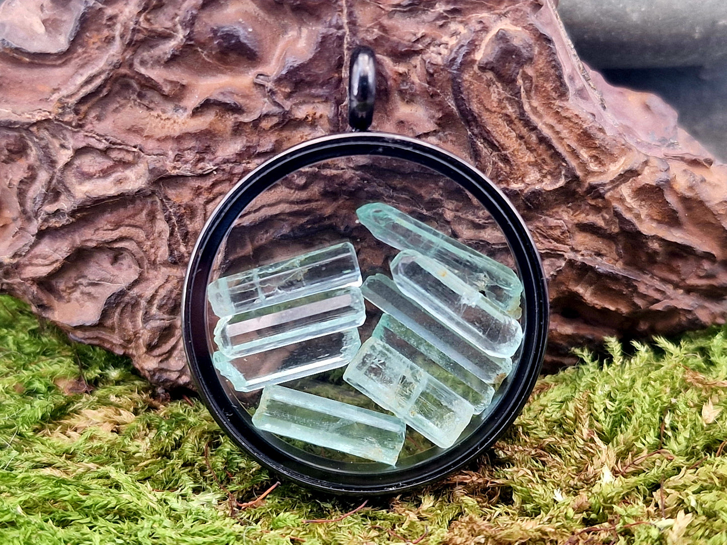 Schwarzfarbener Edelstahlanhänger mit Glasfenster, beidseitig tragbar, gefüllt mit Aquamarin Rohsteinen, 3cm Durchmesser, von Hand individualisiert, Nr.122, Kette im Lieferumfang enthalten