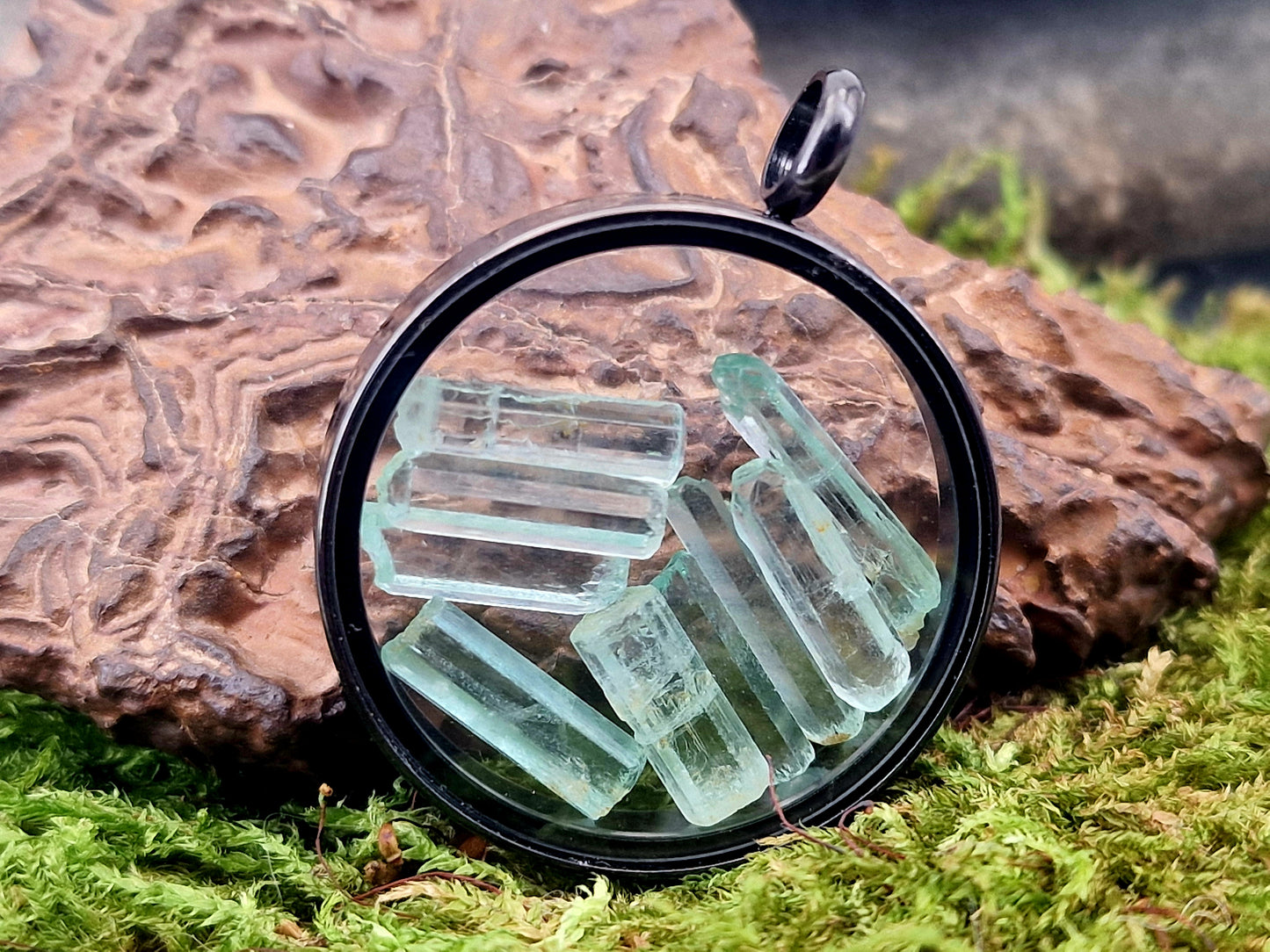 Schwarzfarbener Edelstahlanhänger mit Glasfenster, beidseitig tragbar, gefüllt mit Aquamarin Rohsteinen, 3cm Durchmesser, von Hand individualisiert, Nr.122, Kette im Lieferumfang enthalten