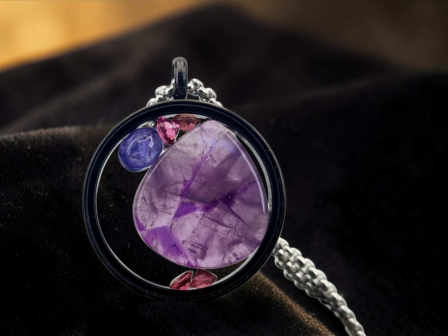 schwarzfarbener Edelstahl/Glas Anhänger, gefüllt mit Amethystscheibe, Turmalin und Tansanit, 3cm Durchmesser, Nr. 145, von Hand individualisiert, Lieferung incl. Edelstahlkette