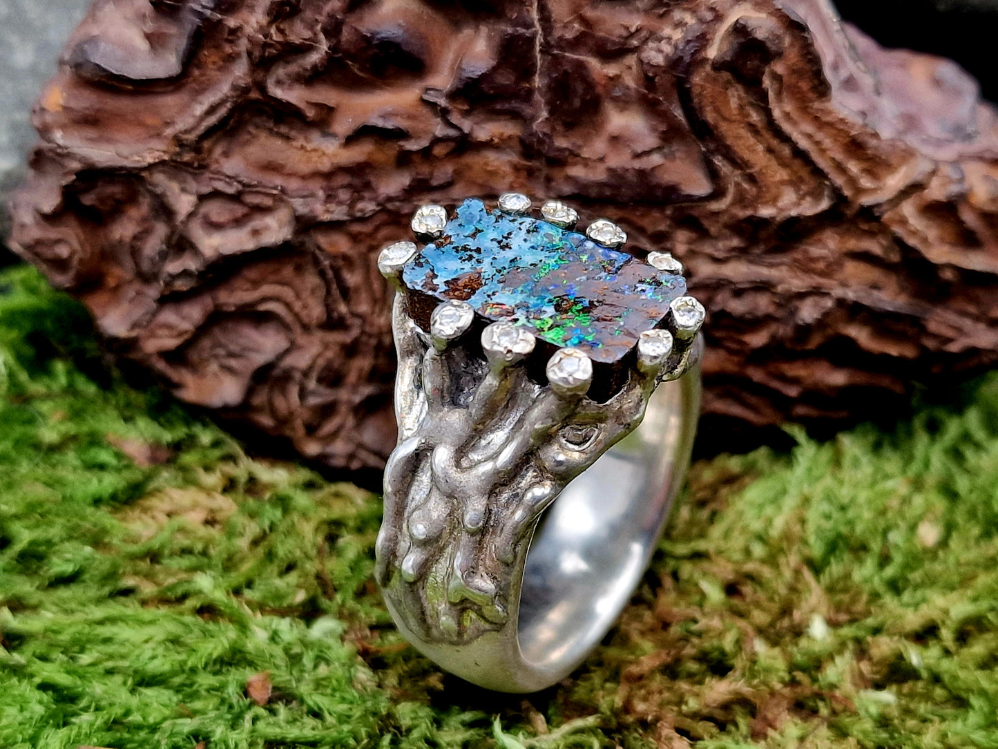 Boulder Opal Design Ring aus 925er Silber, Gr.62 (19,7), massiv, mit 11 facettierten Bergkristallen in den Stotzen der Fassung, wie organisch gewachsen, mehrfarbiges Opalfeuer, Unikat, Handarbeit