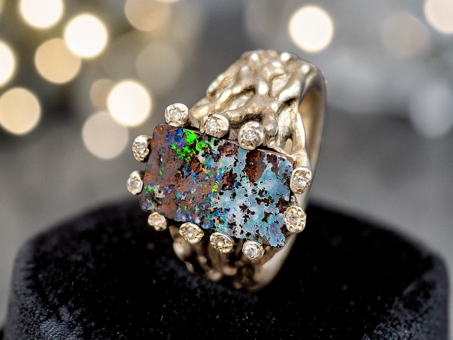 Boulder Opal Design Ring aus 925er Silber, Gr.62 (19,7), massiv, mit 11 facettierten Bergkristallen in den Stotzen der Fassung, wie organisch gewachsen, mehrfarbiges Opalfeuer, Unikat, Handarbeit