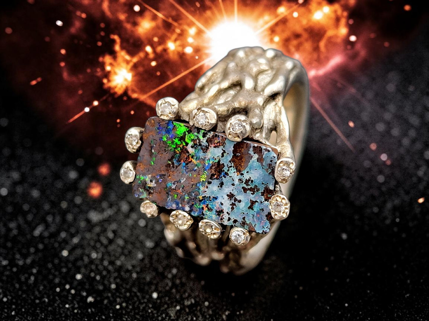 Boulder Opal Design Ring aus 925er Silber, Gr.62 (19,7), massiv, mit 11 facettierten Bergkristallen in den Stotzen der Fassung, wie organisch gewachsen, mehrfarbiges Opalfeuer, Unikat, Handarbeit