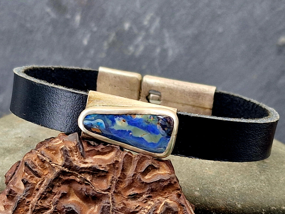 Schwarzes Lederarmband mit Boulder Opal, blaue Grundfarbe, Picture Stone mit partiellem bunten Opalfeuer, Verschluss und Fassung aus 925er Silber, Unisex, Unikat, Handarbeit